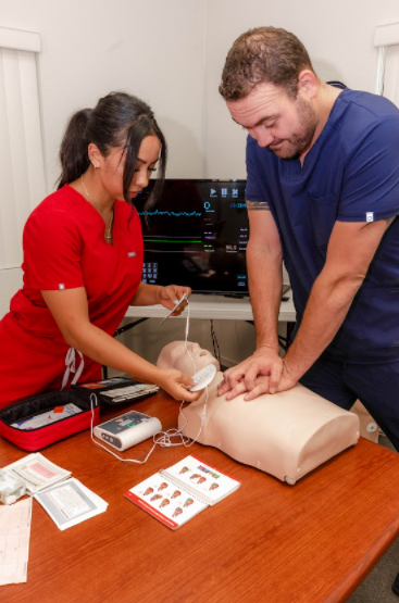 a male nurse leading the CPR performance to an adult male while nurse assistance is placing the ECG pads to the chest for heart beat monitor