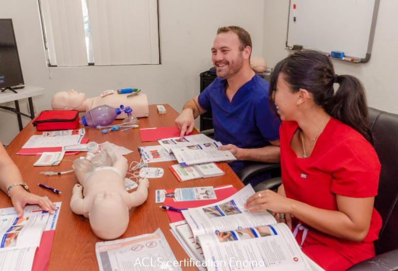 smiling American male doctor and a female nurse during practice of Advanced Cardiovascular Life Support to infant and adult dolls.